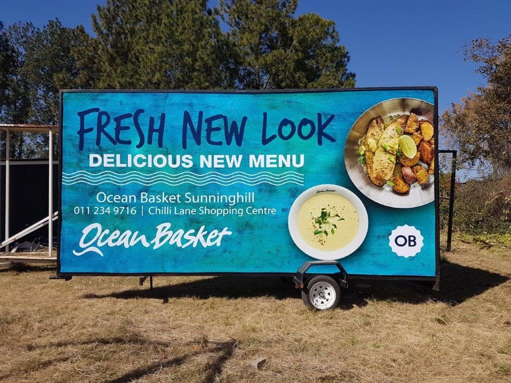 Ocean Basket new menu billboard on a Simply Visible trailer